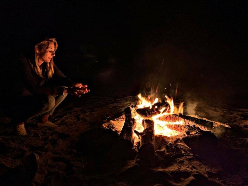 Femme blonde autour d'un feu de camp
